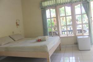 a bedroom with a bed and a large window at Taman Lily's Hotel in Lovina +32 photos