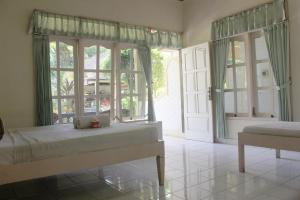 a bedroom with a bed and a large window at Taman Lily's Hotel in Lovina