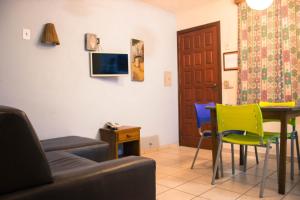 sala de estar con sofá, mesa y sillas en DAPRAIA - APART TAPERAPUAN PRAIA VILLAGE, en Porto Seguro