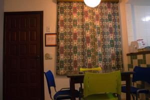a room with a table and chairs and a curtain at DAPRAIA - APART TAPERAPUAN PRAIA VILLAGE in Porto Seguro