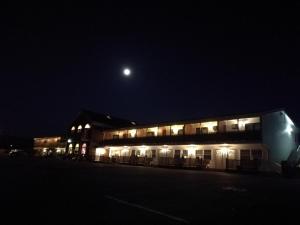 a building at night with the moon in the sky at Laurie's Inn in Chéticamp
