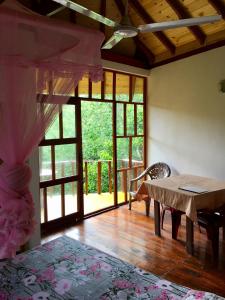 een kamer met een tafel en een groot raam bij Seasons Four Mini Jungle Cabana in Matara