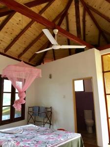 a ceiling fan in a room with a bed at Seasons Four Mini Jungle Cabana in Matara