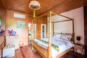 ein Schlafzimmer mit einem Himmelbett in einem Zimmer in der Unterkunft Pao Come Boutique House in Chiang Mai