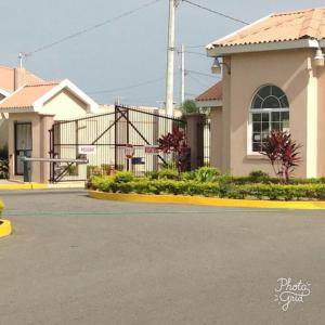 a house with a parking lot in front of a street at Caymanas Estate beautiful 2 bedroom in Ellis Caymanas +1 photo