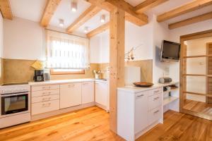 a kitchen with white cabinets and a tv on the wall at Spanglerhaus in Nova Ponente