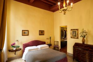 sypialnia z łóżkiem i żyrandolem w obiekcie Campiello Zen B&B w Wenecji