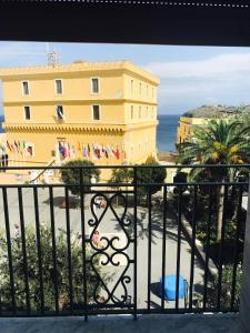 einen Balkon mit einem gelben Gebäude und Meerblick in der Unterkunft Ventotene La casa in Piazza in Ventotene