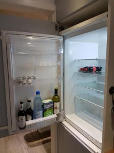 an open refrigerator with bottles of wine and milk at Ferienwohnung Oliver in Fritzlar