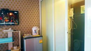 a bathroom with a small refrigerator and a tv at Tonnum Resort in Ban Khlong Khlaeng