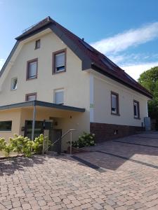 ein großes weißes Gebäude mit einer steinernen Einfahrt in der Unterkunft Boardinghouse Waldbronn in Waldbronn