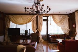 una sala de estar con sofás y una lámpara de araña. en Trikolonion Country Stemnitsa, en Stemnitsa