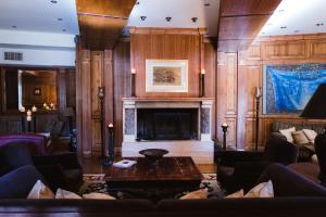 a living room with a fireplace and wooden walls at Trikolonion Country Stemnitsa in Stemnitsa