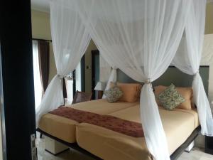 Schlafzimmer mit einem Bett mit weißen Vorhängen in der Unterkunft Nike Villas in Sanur + 37 Fotos