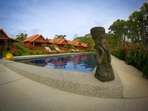 a statue of a woman sitting next to a pool at Thai House Resort in Hua Hin +17 photos