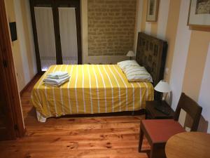 a bedroom with a bed with a yellow blanket at Hotel Rural LaEncomienda in Villarramiel
