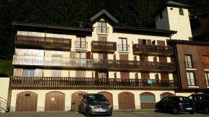 a building with balconies and cars parked in front of it at Grand Studio in Les Carroz d'Araches
