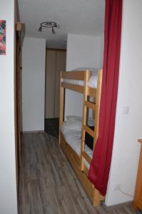 a room with two bunk beds and a red curtain at Grand Studio in Les Carroz d'Araches