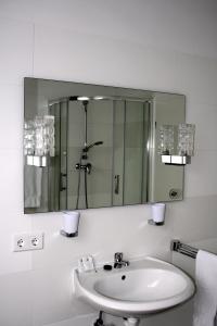 a bathroom with a sink and a mirror at Hotel Zur Heidquelle in Blumenthal