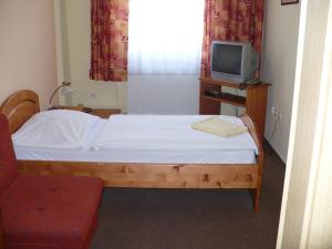małą sypialnię z łóżkiem i telewizorem w obiekcie Motel Ranč w Rużomberku