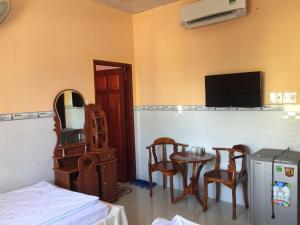 a room with a table and chairs and a television at De Vuong 2 in Cao Lãnh