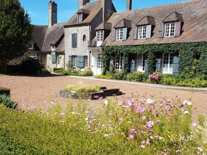 una casa con un jardín de flores delante de ella en Le Cap Hornu en Saint-Valery-sur-Somme