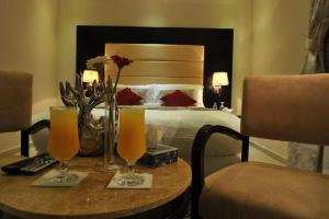 una habitación de hotel con una cama y una mesa con dos vasos en Al Janaderia Suites 7, en Riad