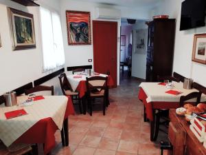 um restaurante com duas mesas com toalhas de mesa vermelhas em Bed & Breakfast 4U PARCHEGGIO INTERNO em Chiavari
