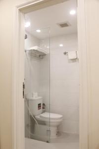 a bathroom with a toilet and a glass shower at BX Apartment in Nha Trang