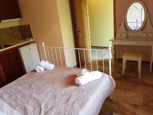 a bedroom with a bed with towels on it at Studios Lefkada in Sívros