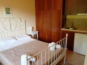 a bedroom with a white bed and a sink at Studios Lefkada in Sívros