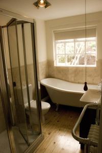 a bathroom with a tub and a toilet and a window at Slieve Donard Cottage Widows Row cottages in Newcastle