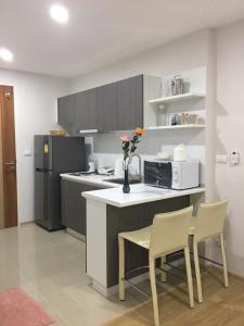 a kitchen with a table and two chairs and a refrigerator at Ozone Condotel by Thawinan in Kata Beach