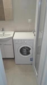 a small bathroom with a washing machine and a sink at Apartments Mira in Medveja