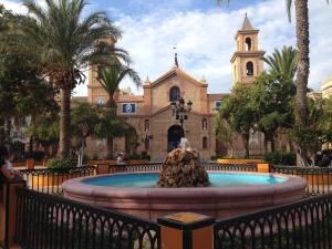 a building with a fountain in front of a church at Apartment Travesia de Santomera in Torrevieja