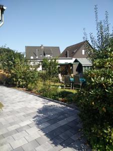 a patio with chairs and trees in front of a house at Apartment Lidija in Hiddenhausen