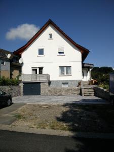 a large white house with a driveway at Apartment Lidija in Hiddenhausen