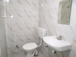 uma casa de banho branca com um WC e um lavatório em Bodhgaya Guest House em Bodh Gaya