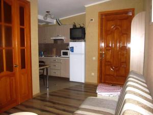 eine Küche mit einem Sofa und einem weißen Kühlschrank in der Unterkunft Apartment on Hoholya 90 in Kropywnyzkyj