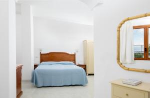 a bedroom with a bed and a mirror at Hotel Pupetto in Positano