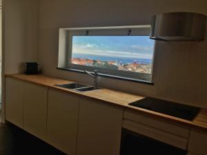 a kitchen with a sink and a window with a view at Casa do Pisão - Cosy and Modern Two-Bedroom Townhouse in Angra do Heroísmo