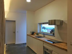 een keuken met een wastafel en een raam bij Casa do Pisão - Cosy and Modern Two-Bedroom Townhouse in Angra do Heroísmo