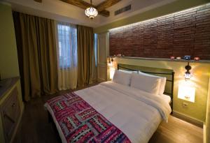 1 dormitorio con 1 cama grande y pared de ladrillo en No12 Boutique Hotel, en Tiflis