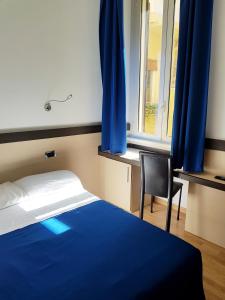 1 dormitorio con 1 cama, 1 silla y 1 ventana en Hotel Louisiana, en Roma
