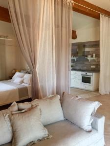 a bedroom with a bed and a couch at Mas la Pinede in Saint-Marc-Jaumegarde