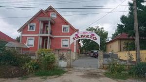 een rood huis met een bord ervoor bij Flamingó Panzió in Székesfehérvár