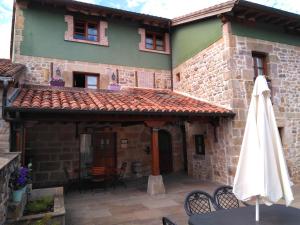 - une vue sur l'extérieur d'un bâtiment avec une table et un parasol dans l'établissement Los Mantos - Vivienda Rurales, à Ibio