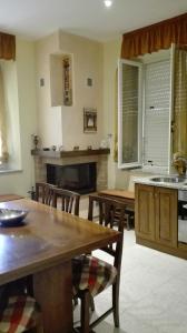 una cucina con tavolo, sedie e camino di Casa Rovere Perugia a Perugia