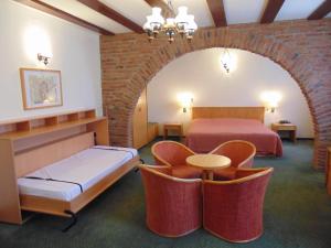 a hotel room with two beds and chairs in it at Curtea Brasoveana in Braşov