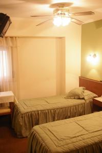 a hotel room with two beds and a ceiling fan at Hotel Compostela in Mar del Plata